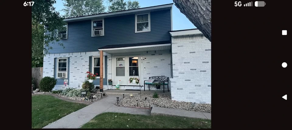 A Solara Labor Group project: a home with a blue upper exterior and freshly finished white brick