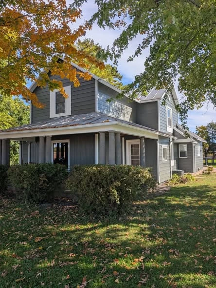 Grey-painted home exterior with a covered porch and white trim