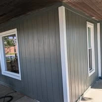 Close view of grey exterior siding, porch, and white trim