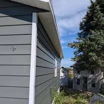 Close view of grey exterior siding, porch, and white trim