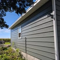 Close view of grey exterior siding, porch, and white trim
