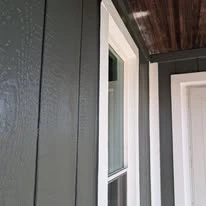 Close view of grey exterior siding, porch, and white trim