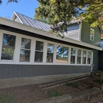 Close view of grey exterior siding, porch, and white trim