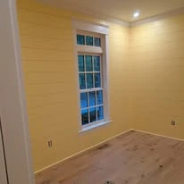 Interior room with painted walls, white trim, and plank flooring