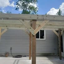 Wooden pergola structure alongside a home