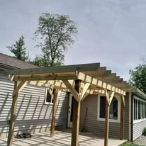 Wooden pergola structure alongside a home